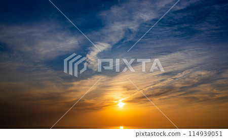The setting sun and flowing clouds in the evening sky 114939051