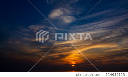 The setting sun and flowing clouds in the evening sky The setting sun and flowing clouds in the evening sky 114939113