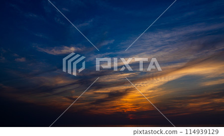 The setting sun and flowing clouds in the evening sky The setting sun and flowing clouds in the evening sky 114939129