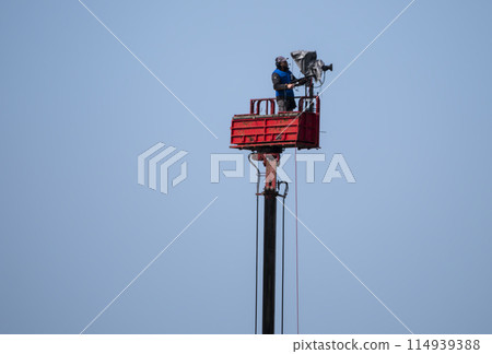 View of a professional camera operator on top of tower for high ground view View of a professional camera operator on top of tower for high ground view 114939388