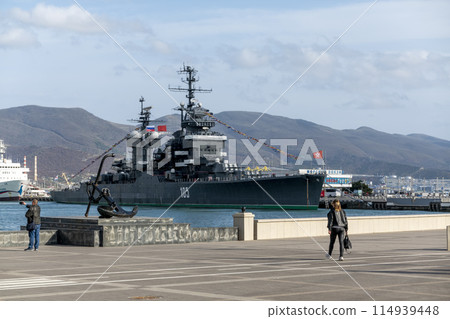 Novorossiysk, Russia - 18 August 2023. Cruiser Mikhail Kutuzov and dolphins, Black Sea, port, Krasnodar Territory, Novorossiysk. 114939448