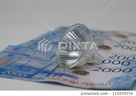 White electric cable and banknotes, expensive electricity, saving electricity. White electric cable and banknotes, expensive electricity, saving electricity. 114939559