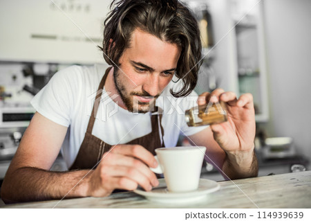 Handsome barista working in coffee shop, preparing coffee. University student working part-time in cafe. 114939639