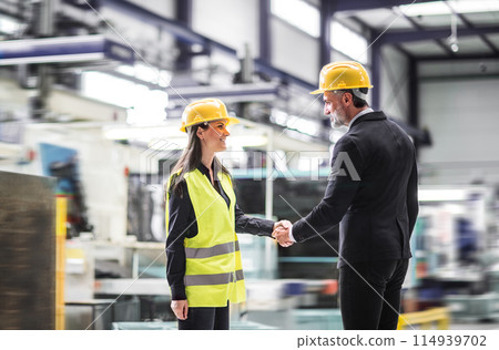 Female warehouse manager talking with logistics employee in warehouse, planning transport of products, goods, talking shipping process. Female warehouse manager talking with logistics employee in warehouse, planning transport of products, goods, talking shipping process. 114939702