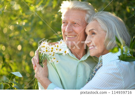Portrait of beautiful senior couple by lilacs in the park Portrait of beautiful senior couple by lilacs in the park 114939716