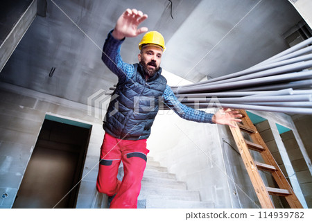 Man falling off the ladder. Accident of a man worker at the construction site. Work injury, accident in workplace. 114939782