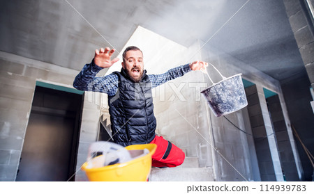 Man falling down the stairs. Accident of a man worker at the construction site. Work injury, accident in workplace. Man falling down the stairs. Accident of a man worker at the construction site. Work injury, accident in workplace. 114939783