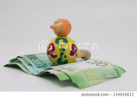 Bird nest with banknotes and a wooden bird whistle. Family budget. Bird nest with banknotes and a wooden bird whistle. Family budget. 114939815