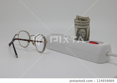 White electric cable and banknotes, expensive electricity, saving electricity. White electric cable and banknotes, expensive electricity, saving electricity. 114939869