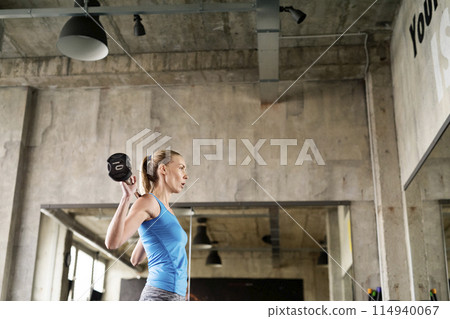 Woman lifting barbell off the ground. Routine workout for physical and mental health. Woman lifting barbell off the ground. Routine workout for physical and mental health. 114940067