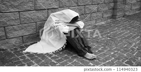 Sad woman sitting on the ground Sad woman sitting on the ground 114940323