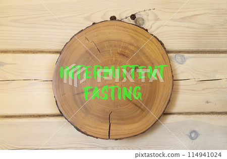 Intermittent fasting symbol. Concept words Intermittent fasting on beautiful wooden circle. Beautiful wooden wall background. Healthy lifestyle intermittent fasting concept. Copy space. 114941024
