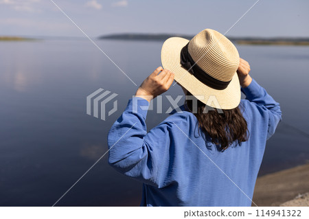 young woman in a straw hat, background of the blue sea young woman in a straw hat, background of the blue sea 114941322