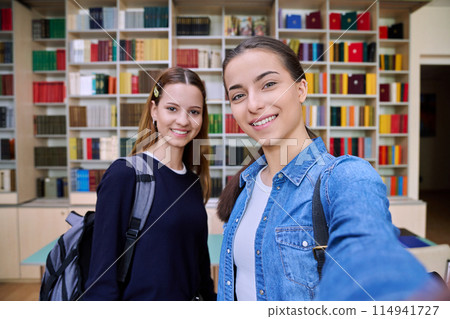 Selfie portrait of two girls high school students looking at camera inside classroom Selfie portrait of two girls high school students looking at camera inside classroom 114941727