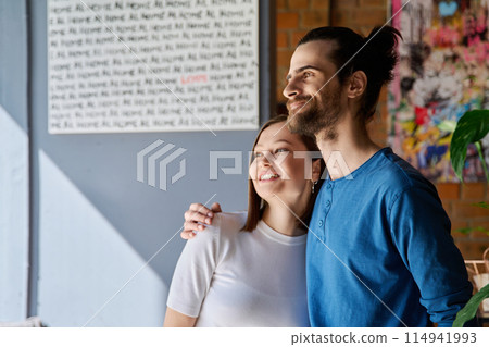 Young happy couple hugging together looking out the window 114941993
