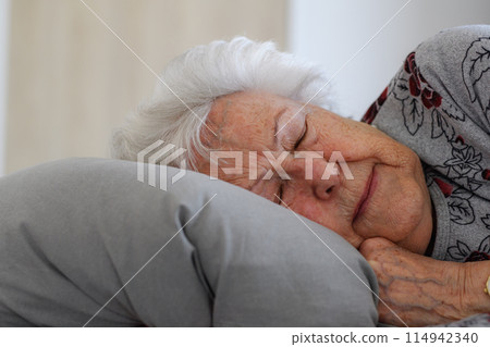 Senior woman sleeping in her bed alone, feeling anxious. Loneliness, social isolation of eldery woman. 114942340