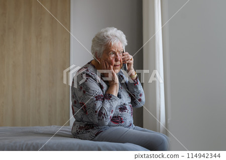 Senior woman making phone call, receiving bad news. Concept of loneliness and dependence of older people. Senior woman making phone call, receiving bad news. Concept of loneliness and dependence of older people. 114942344