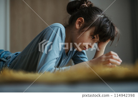 Young schoolgirl struggling with learning at home, doing homework. Learning difficulties in children 114942398