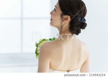 Back of a bride holding a bouquet 114943254