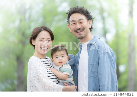 Middle-aged couple walking in the fresh greenery, looking at the camera Middle-aged couple walking in the fresh greenery, looking at the camera 114944021