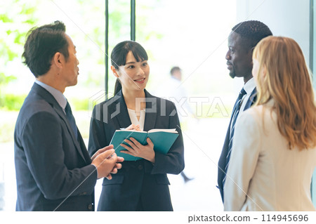 A group of multinational business people having a conversation in a lobby through an interpreter 114945696