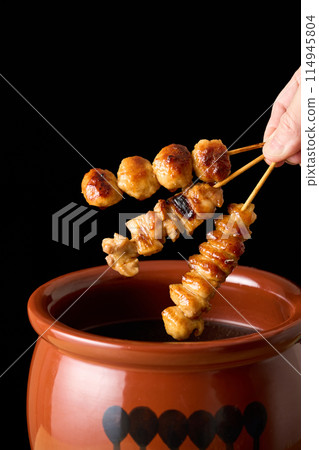 Dip the yakitori (negima, tsukune, and tuna tail) in the sauce. 114945804