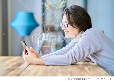 在房間裡操作智能手機的女人 在房間裡操作智能手機的女人 114945993