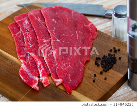 Uncooked beef fillet with black pepper on table Uncooked beef fillet with black pepper on table 114946225