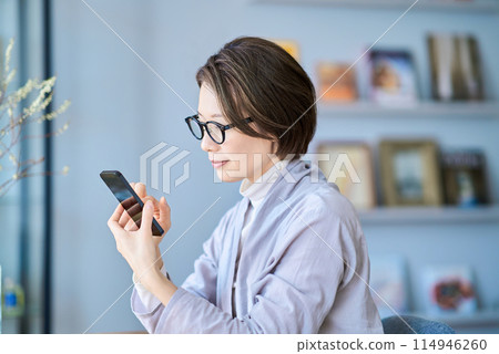 A tired woman operating a smartphone A tired woman operating a smartphone 114946260