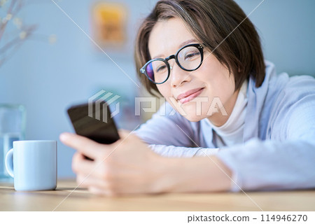 A tired woman operating a smartphone A tired woman operating a smartphone 114946270