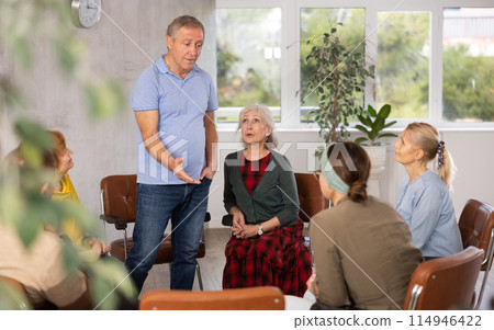 Older male psychologist conducting a group session with mature clients Older male psychologist conducting a group session with mature clients 114946422