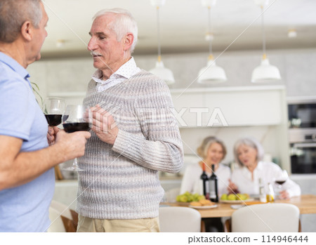Two elderly men friends talking in kitchen 114946444