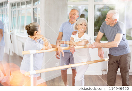 Elderly ballet lovers communicate with each other during break between classes in choreographic studio 114946460