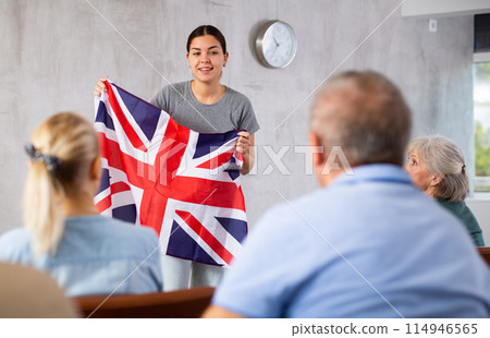 Young female teacher showing british flag to mature students 114946565