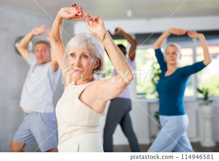 Senior lady enjoying flamenco during group dance class 114946581