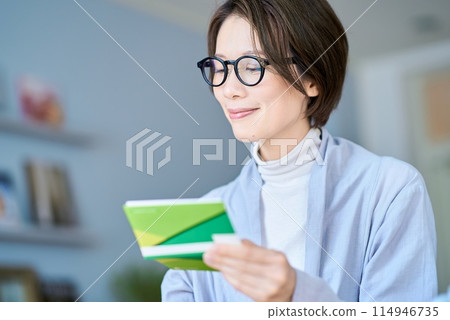 A woman looking at her bank account passbook A woman looking at her bank account passbook 114946735