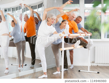 Ballet pose grand batman - elderly women and men at choreography lesson 114946980