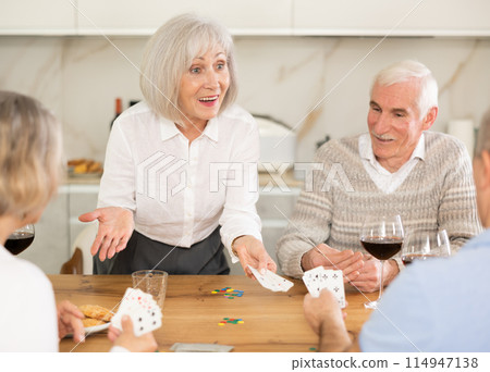 Couples of elderly women and men playing poker 114947138