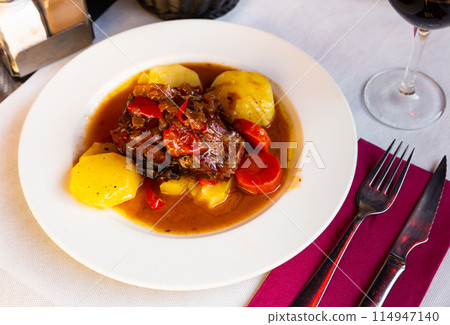 Baked lamb shoulder with vegetables 114947140