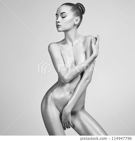 Sexy naked girl with a beautiful body posing in a photo studio. Sexy naked girl with a beautiful body posing in a photo studio. 114947796