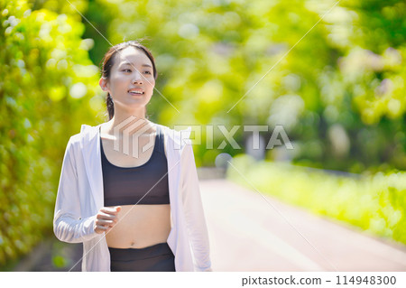 穿著運動服行走的年輕女子 穿著運動服行走的年輕女子 114948300