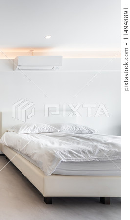 Air conditioner and bed in a white minimal style room. Air conditioner and bed in a white minimal style room. 114948891