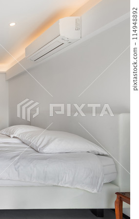Air conditioner and bed in a white minimal style room. Air conditioner and bed in a white minimal style room. 114948892