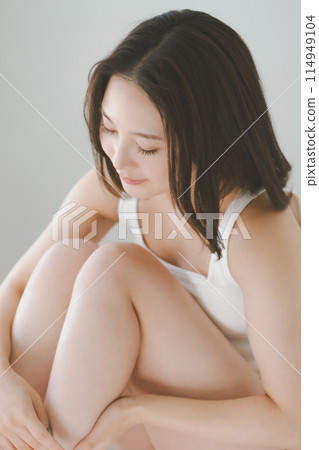 一位 20 多歲的女性正在為自己做小腿和腿部瘦身按摩 114949104