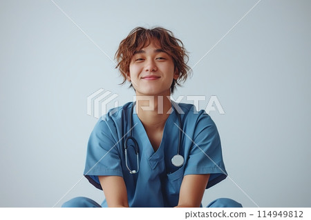 Cheerful young nurse sitting cross-legged 114949812