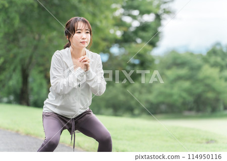 Asian woman doing squats, bodyweight training, and lower body training in the park (diet, exercise) 114950116