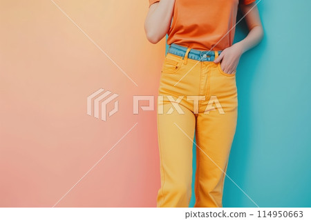 Woman in yellow pants stands against ombre wall 114950663
