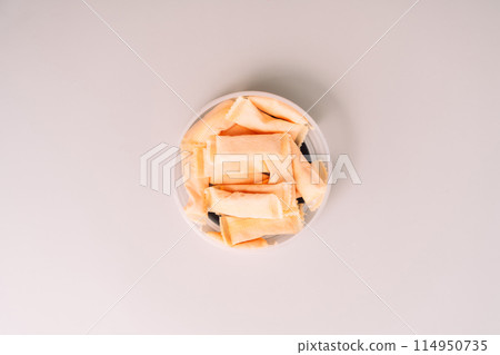 Open plastic jar with sachets of non-smoking tobacco product with fruity flavor on a light background 114950735