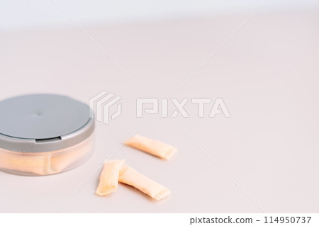 Plastic jar with bags of non-smoking tobacco product with fruity flavor on a light background 114950737