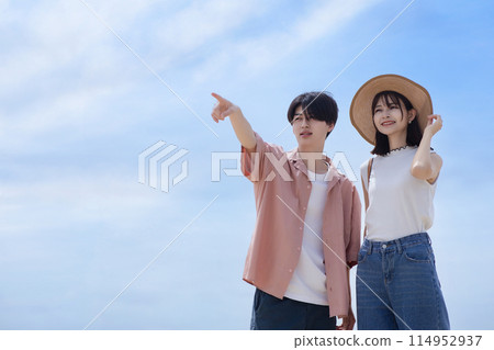 A young couple walking along the beach A young couple walking along the beach 114952937